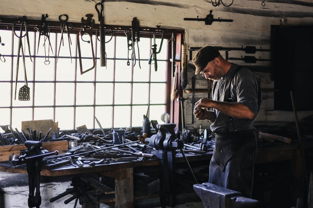 Hombre trabajando en un taller repleto de herramientas