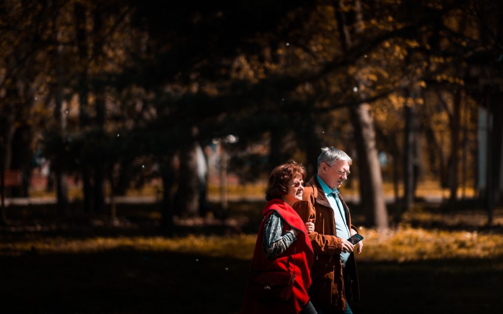 Hombre y mujer de mediana edad caminando entre los árboles