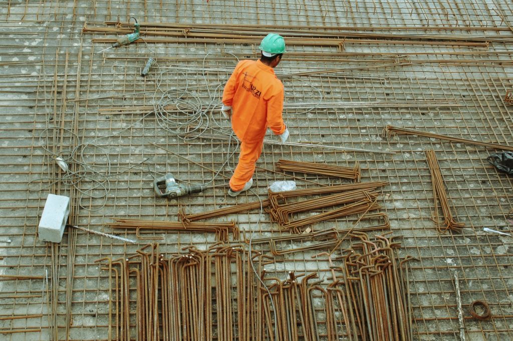 Hombre con traje naranja trabajando en una obra de construcción Hombre con traje naranja trabajando en una obra de construcción