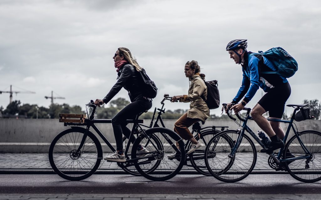 Tres personas andando en bicicleta en día nublado