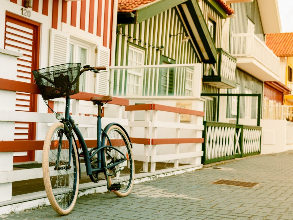 Bicicleta blanca y negra estacionada al lado de un cerco
